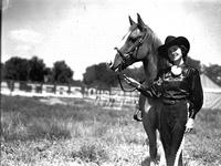 [Unidentified cowgirl posed by horse]
