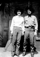 [Possibly Iva Del Jacobs and Hoot Gibson stand side by side in front of building]