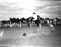 [Unidentified Cowboy off bronc with right hand in dirt right foot still in stirrup]