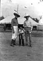 [Autry standing with unidentified man and little boy, all in western gear]
