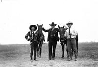 [Doubleday standing between two horses tended by two unidentified cowboys]