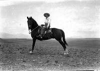 [Unidentified Cowgirl on horse standing stretched]