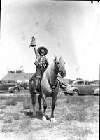 [Unidentified cowgirl with gauntleted hand raised]