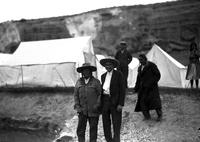 [Chief Plenty Coups wearing glasses standing beside Ralph Doubleday and man in western attired]