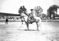 [Unidentified older man in suit, boots, and western hat atop horse]