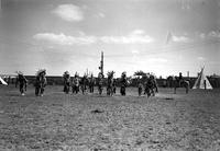 [Group of Indian dancers with cowboy (possibly Ricker) and tipi in background]