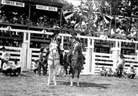 [Possibly Vaughn Krieg and Lynn Huskey on horseback in arena]