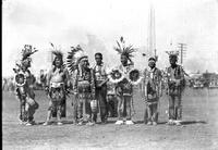 [Group of seven Indian men and boys; six in native dress, middle one appears to be in Mexican dress]