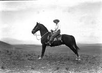 [Unidentified cowgirl atop stretching horse]