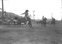 [Unidentified cowgirl riding bronc]