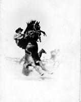 [Unidentified Cowboy on bronc who has bucked perpendicular to ground]