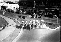 [Six unidentified white-costumed cowgirls on white horses each bearing a flag that flew over Texas]