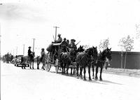 [Four-horse team pulling stagecoach with men & women in 19th century dress aboard]