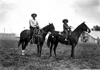 [Unidentified man and little girl atop horses]