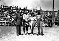 [Jenkins, Cremer, unidentified actress (possibly Durbin) and Bellamy standing back to grandstands]