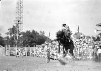 [Unidentified Cowboy riding airborne bronc]