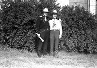 [Johnnie Lee Wills and Mayo standing in front of bushes]