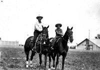 [Unidentified man and little girl atop horses]