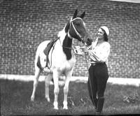 [Unidentified woman standing beside horse]