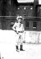 [Cy Compton posed in front of chain-link fence]