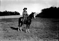 [Possibly Josephine Proctor on horseback in field surrounded by wooden fence]