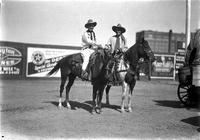 [Two unidentified cowboys on Pinto horses, one horse has star breast collar]