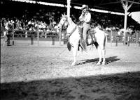 [Unidentified cowgirl on horseback in front of grandstand]