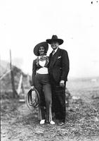 [Unidentified cowgirl with whip standing beside Ralph R. Doubleday]