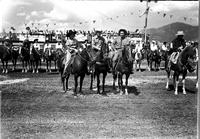 [Possibly Margie Greenough in a large group of Cowboys and Cowgirls on horseback in arena]