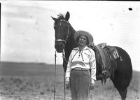 [Unidentified older cowgirl posed by horse]