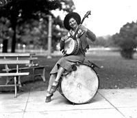 [Cowgirl banjo player from Buck Taylor's cowgirl band sitting on bass drum]
