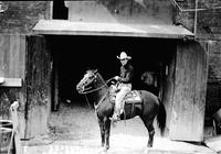 [Col. Jim Eskew on horse in front of barn entrance]