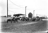 [Group of unidentified cowboys lined up in arena]