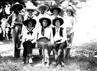 [California Frank, Mamie Francis, and six cowgirls in pose]