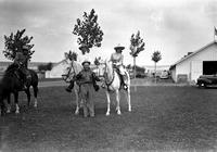 [Leo Cremer and Possibly Sally Rand on matched white horses being held by unidentified man]