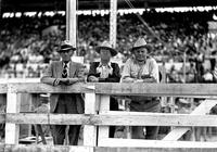 [Leo Cremer and two unidentified cowboys leaning on fence]