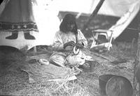 [Indian woman weaving basket, decorated tipi in background]