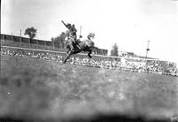 [Unidentified Cowboy a bit out of the saddle riding bronc]