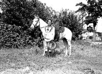 [Brady standing with white horse "Pal"]