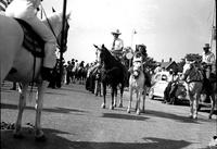 [Cowboy on horseback with young cowgirl on pony]