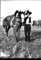 [Two unidentified cowgirls(possibly Opal Reger on right)standing on either side of a horse's head]