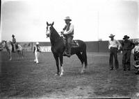 [Unidentified heavy-set man in Hat, Tie and Vest on horse, cowboys in background]