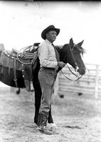 [Possibly Eddie McCarty wearing necktie standing in profile by horse]