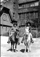 [Possibly Tom and Junior  Eskew horseback in front of building]