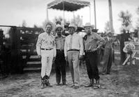 [Autry in flowered shirt standing with three unidentified men]