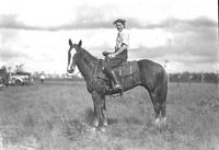 [Unidentified woman posed atop horse]
