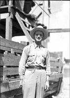 [Unidentified spectacled man in western clothes standing by chutes]