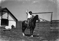 [Possibly Eddie McCarty with rope in hand on horseback in front of corral]