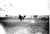 [Unidentified Cowboy hanging on to bronc]