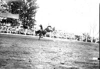 [Unidentified Cowboy riding and staying with saddle bronc]